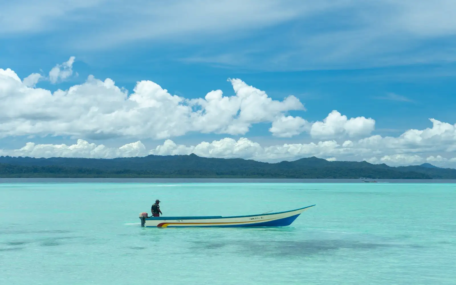 Chiếc tàu gỗ nhỏ neo trên vùng nước xanh ngọc giữa Raja Ampat